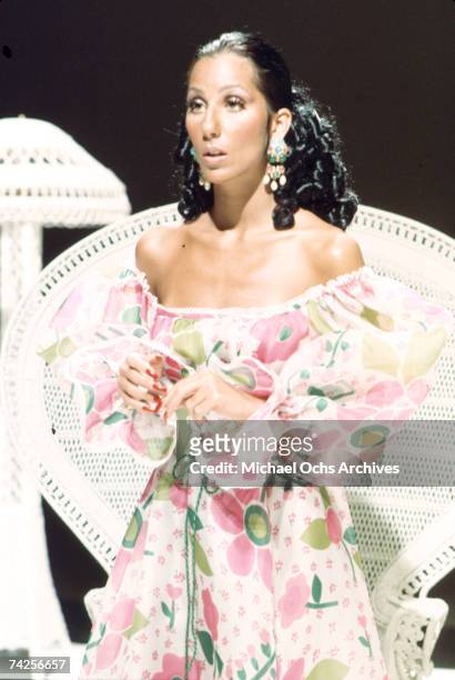 Entertainer Cher performs while sitting in a wicker chair in circa 1974 in Los Angeles, California.