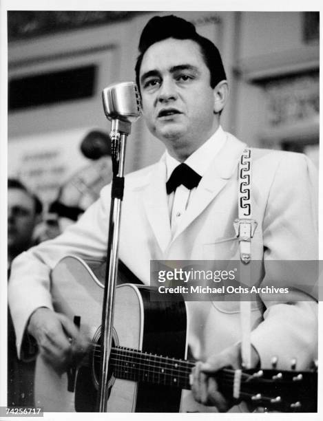 Country singer Johnny Cash performs onstage with an acoustic guitar in circa 1958.