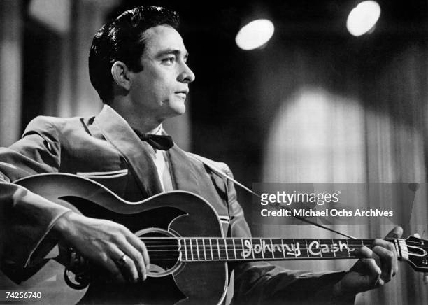 Country singer/songwriter Johnny Cash performs onstage with an acoustic guitar in Sun Records publicity shot in 1957.