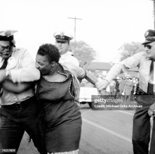 An African American woman bites a policeman during a protest against segregation organized by Reverend Dr. Martin Luther King Jr. And Reverend Fred...