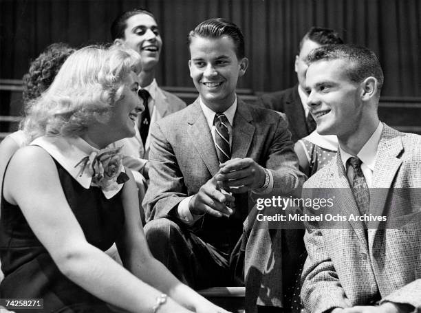 Television show host Dick Clark poses for a portrait with some kids that are on the set of his show "American Bandstand" in circa 1957.