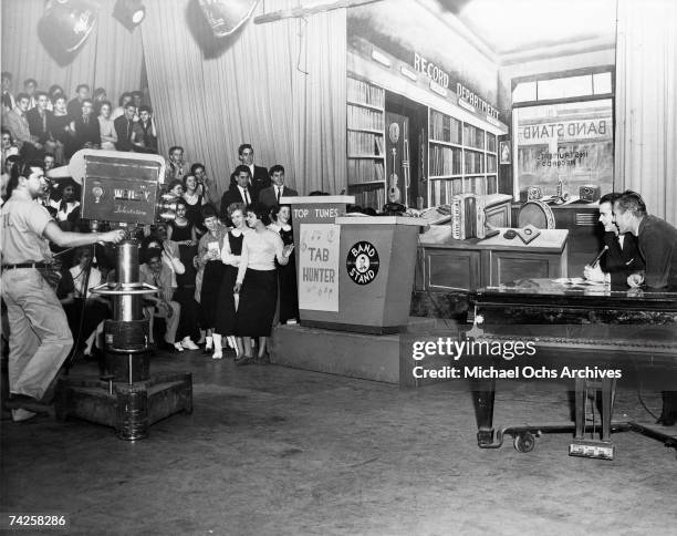 Pop singer Tab Hunter and host of the television show "American Bandstand" Dick Clark chat on stage in front of a studio audience in circa 1957 in...