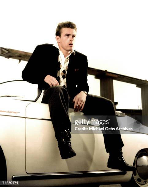 Actor James Dean poses for a portrait sitting on his Porche Speedster in 1955 in Los Angeles, California.
