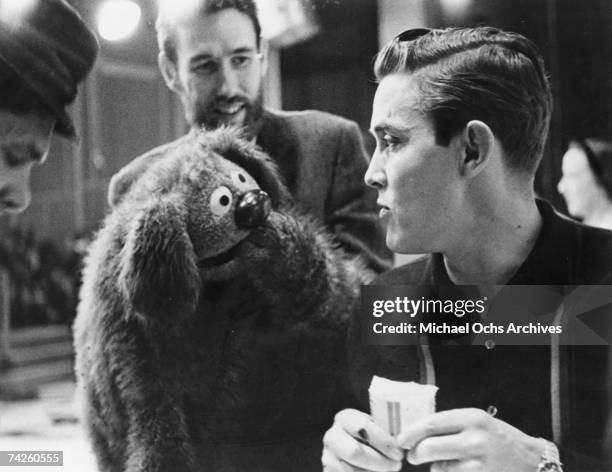 Muppets creator Jim Henson, , manipulates one of his creations as it engages in conversation with singer Jimmy Dean in 1963.