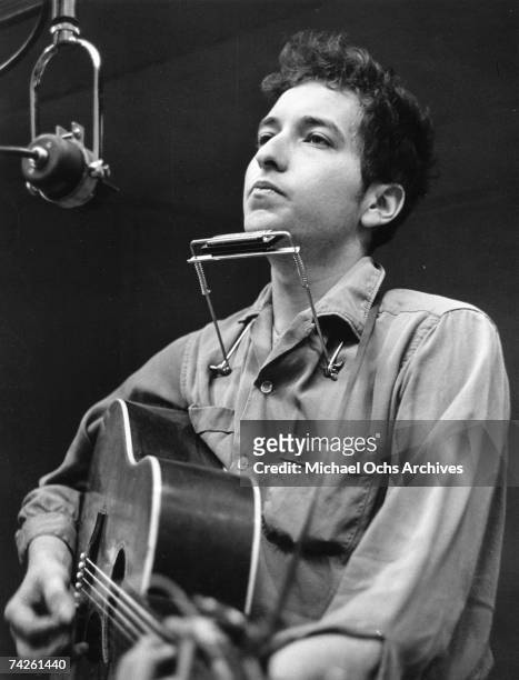 Bob Dylan recording his first album, "Bob Dylan", in front of a microphone with an acoustic Gibson guitar and a harmonica during one of the John...