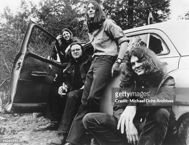 Pat Simmons, John Hartman, Dave Shogren and Tom Johnston of the rock and roll band "The Doobie Brothers" pose for a portrait with a car in circa 1970.