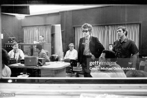 Bob Dylan and his manager Albert Grossman listen back to the recordings of the album 'Highway 61 Revisited' surrounded by engineers and other...