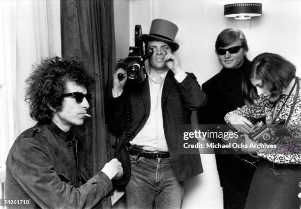 Bob Dylan smokes a cigarette as D.A. Pennebaker films for the documentary film 'Don't Look Back' about Dylan's 1965 tour of England.