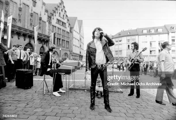 Ray Manzarek, John Densmore hidden behind Jim Morrison and Robbie Krieger perform on the street on September 14, 1968 in Frankfurt Germany,