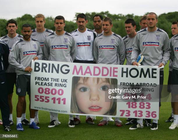 The England players hold a banner for the safe return of missing child Maddie McCann, before England B team training at the Carrington training...