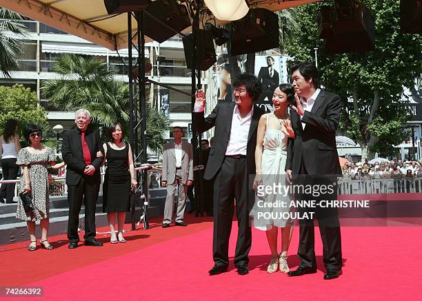 South Korean actors Kang-Ho Song and Do-Yeon Jeon and South Korean director Lee Chang-Dong wave to the crowd 24 May 2007 upon arriving in the...