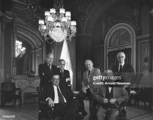 Portrait of six American journalists as they pose together under a large chandelier, September 1984. Pictured are, back row from left, American...