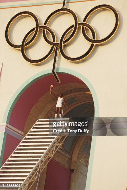 Olympic decathlete gold medallist Rafer Johnson of the United States after climbing the stairs of the Memorial Coliseum prepares to light the Olympic...