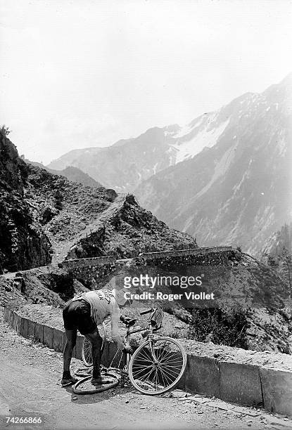 Italian cyclist Vicenzo Borgarello's fixing a flat tyre during the Grenoble-Nice stage of the 1912 Tour de France.