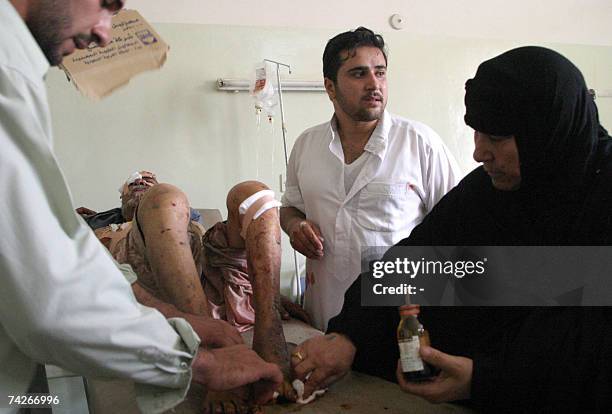Iraqi medics treat a man wounded at a hospital after a car exploded at the funeral of the murdered nephew of a local tribal leader in the western...