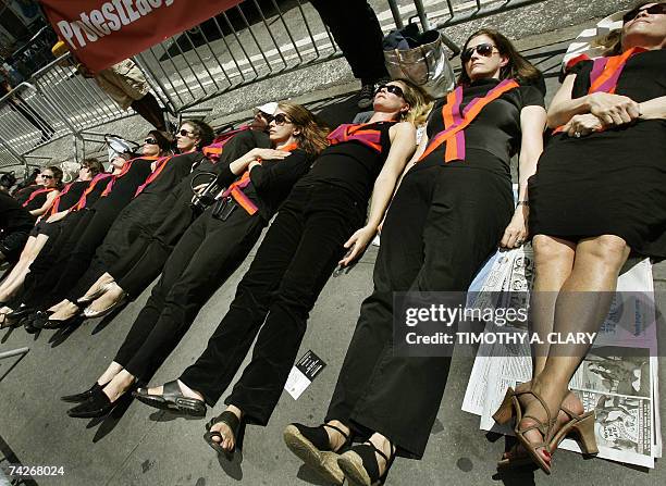 New York, UNITED STATES: Thirty-two female protesters wearing black and ribbons with the Virginia Tech University colors lie down in Times Square in...