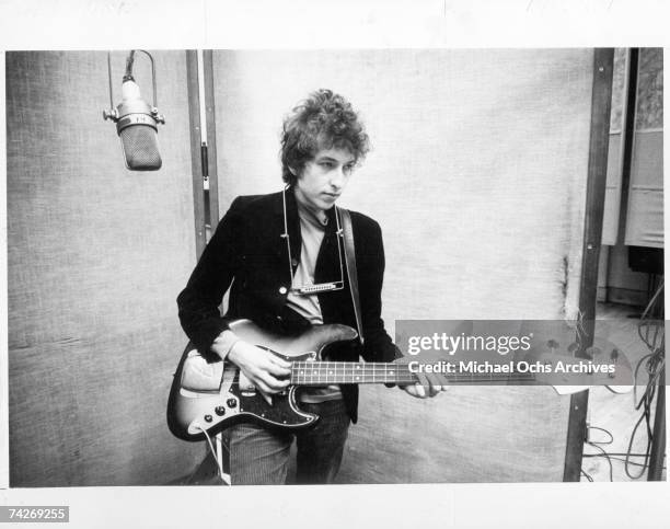 Bob Dylan plays a Fender Jazz bass with the harmonica around his neck while recording his album 'Bringing It All Back Home' on January 13-15, 1965 in...