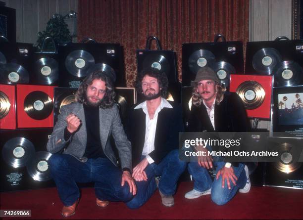Don Felder, Don Henley, and Joe Walsh of the rock band "Eagles" pose for a portrait with gold records in 1978.