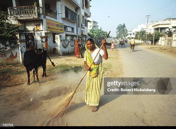 Woman of the Harijan caste sweeps the street October 28, 1991 in India. The Harijan caste is the lowest in the Hindu class hierarchy and its members...