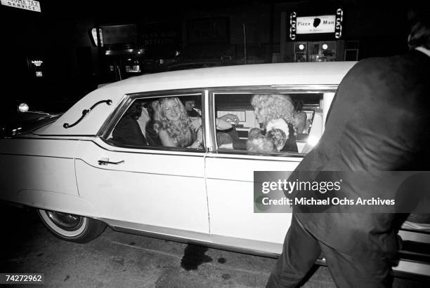 Rock band 'Led Zeppelin' ride in a white limousine adorned with various groupies outside of Rodney Bingenheimer's English Disco in June 1972 in Los...