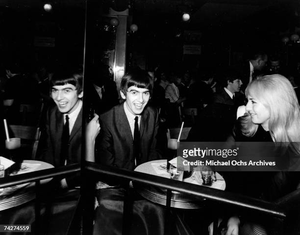 Guitarist George Harrison of the rock and roll band "The Beatles" sits at a table with Cynthia Lennon at The Peppermint Lounge on their first night...