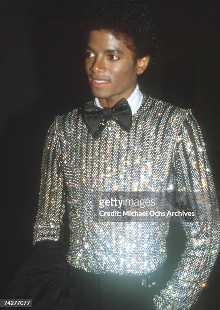 Pop singer Michael Jackson attends an event wearing a sequined shirt and a bow tie in 1979.