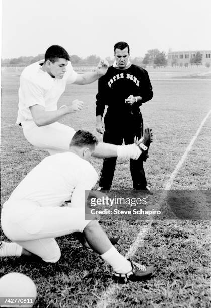 View of University of Notre Dame football coach Ara Parseghian as he watches his kicking team practice on the field, South Bend, Indiana, 1964.