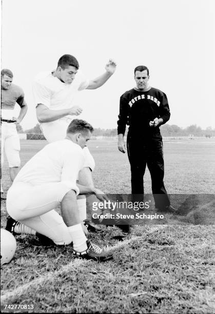 View of University of Notre Dame football coach Ara Parseghian as he watches his kicking team practice on the field, South Bend, Indiana, 1964.