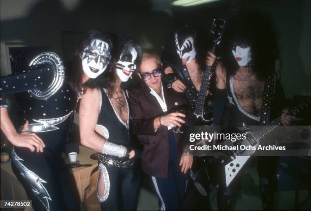 Pop singer Elton John poses for a portrait with the rock band 'Kiss' in full regalia in circa 1977 in Los Angeles, California. Ace Frehley, Peter...