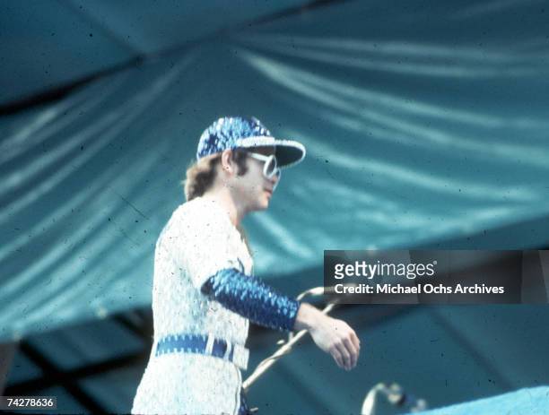 Pop singer Elton John performs onstage at Dodger Stadium in a blue and white sequined outfit Dodgers uniform on October 25, 1975 in Los Angeles,...
