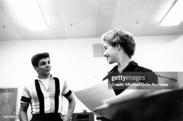 Songwriter Carole King and singer Johnny Restivo chat between takes in a recording studio in New York, New York, circa 1959.