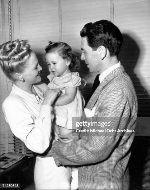 Jazz singer Peggy Lee and her husband Dave Barbour hold their baby girl in the Capitol Records office on November 3, 1945 in Los Angeles, California.