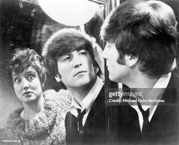 John Lennon of the rock and roll band 'The Beatles' in a still with an actress from their movie 'A Hard Day's Night' which was released on August 11,...