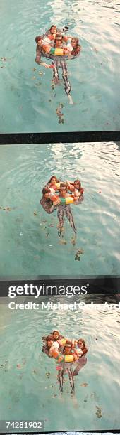 Mama Cass Elliott, John Phillips, Michelle Phillips, Denny Doherty of the folk group "The Mamas And The Papas" pose for a portrait session in a pool...