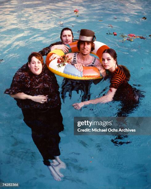 Mama Cass Elliott, John Phillips, Michelle Phillips, Denny Doherty of the folk group "The Mamas And The Papas" pose for a portrait session in a pool...