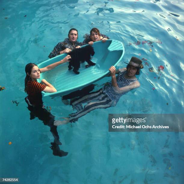 Mama Cass Elliott, John Phillips, Michelle Phillips, Denny Doherty of the folk group "The Mamas And The Papas" pose for a portrait session in a pool...