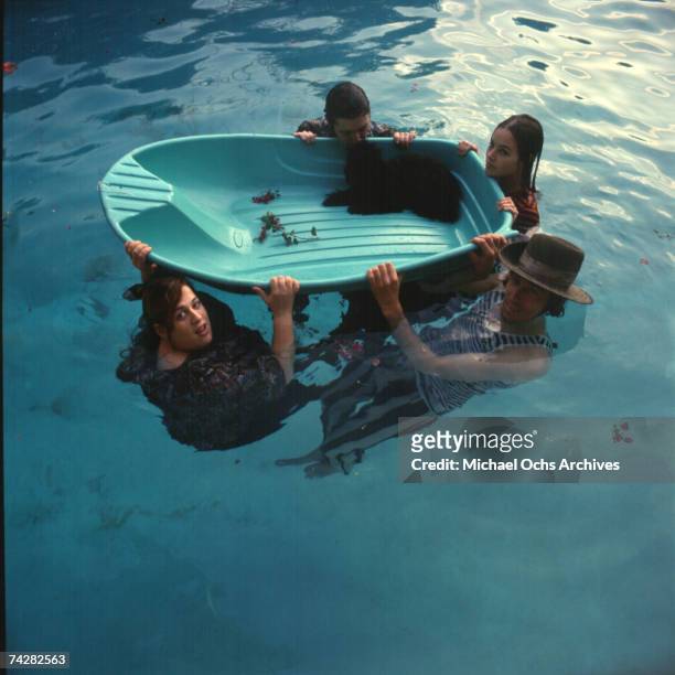 Mama Cass Elliott, John Phillips, Michelle Phillips, Denny Doherty of the folk group "The Mamas And The Papas" pose for a portrait session in a pool...