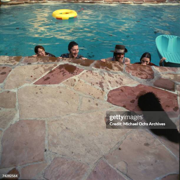 Mama Cass Elliott, John Phillips, Michelle Phillips, Denny Doherty of the folk group "The Mamas And The Papas" pose for a portrait session in a pool...