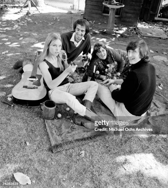 Denny Doherty, Michelle Phillips, John Phillips and Mama Cass Elliott have an acoustic guitar jam and picnic in circa 1966 in a park.