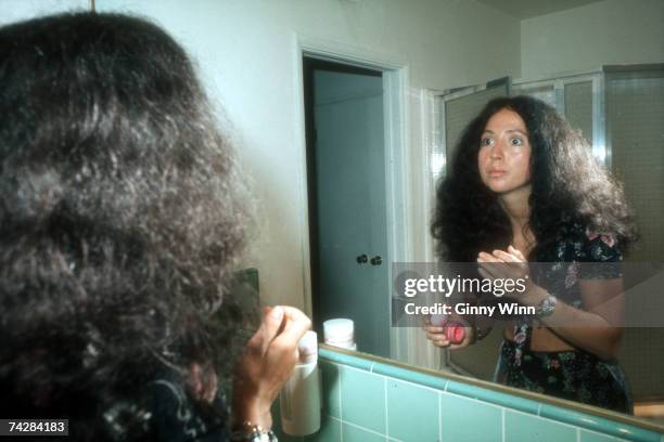 Singer Maria Muldaur prepares her make up in the mirror before performing onstage in circa 1974.