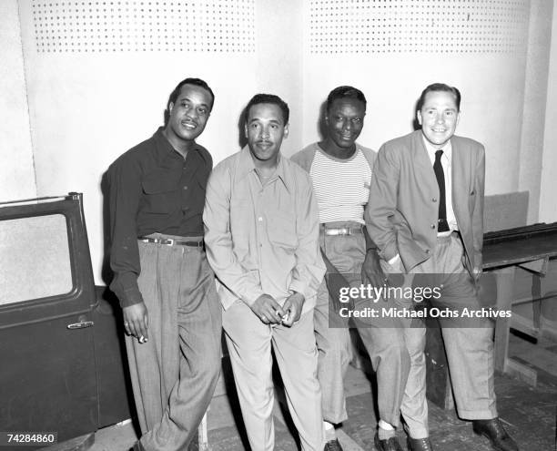 Bassist Johnny Miller, guitarist Oscar Moore and pianist Nat 'King' Cole of the "Nat 'King' Cole Trio" pose for a portrait with Johnny Mercer in...