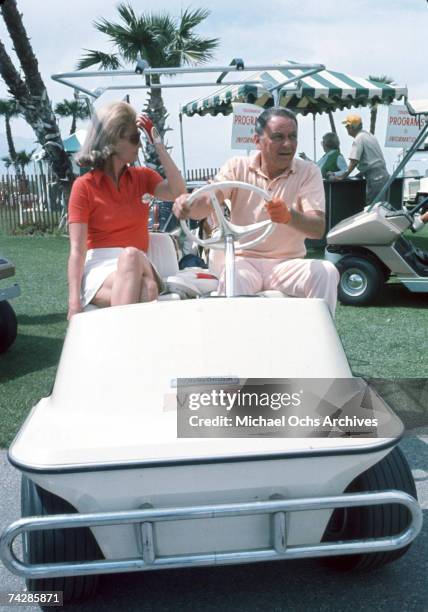 Pop singer Frank Sinatra rides on a golf cart with Barbara Marx, whom he would later marry, at a celebrity golf tournament in October 1971.