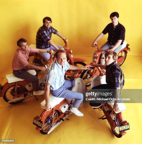 Rock and roll band "The Beach Boys pose for a portrait with some Honda mopeds in circa 1964. Clockwise from lower right: Dennis Wilson, Mike Love, Al...