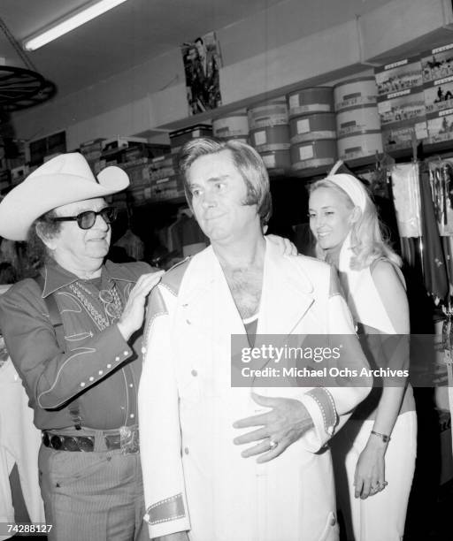 Celebrity tailor Nudie Cohn and country singers George Jones and Tammy Wynette at Nudies Rodeo Tailors on May 26, 1973 in North Hollywood, Los...