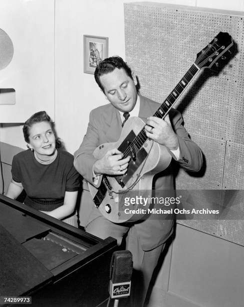 Husband and wife songwriting duo Les Paul & Mary Ford perform on electric guitar and piano at a Capitol Records microphone in circa 1952.