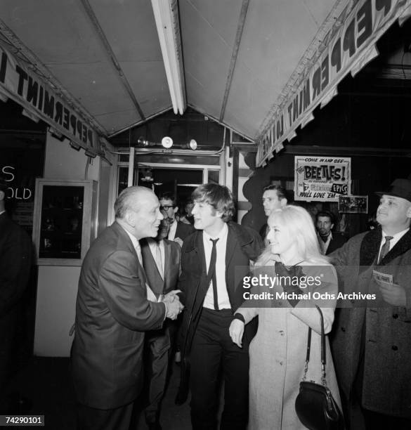 Singer and guitarist John Lennon of the rock and roll band 'The Beatles' and his wife Cynthia Lennon are greeted when they arrive at the Peppermint...