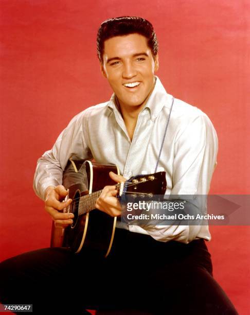 Rock and roll musician Elvis Presley strums an acoustic guitar while posing for a portrait in September 1962 in Culver City, California at MGM...