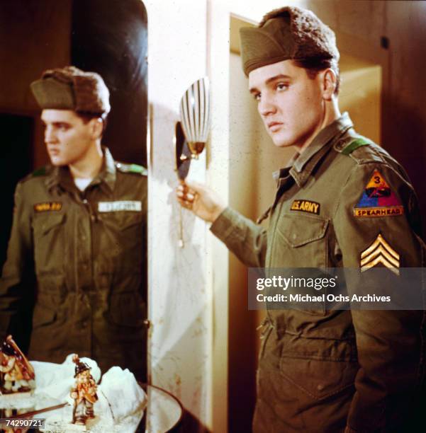 Rock and roll singer Elvis Presley poses for a portrait next to a mirror during his tour of duty in Germany in February of 1959.