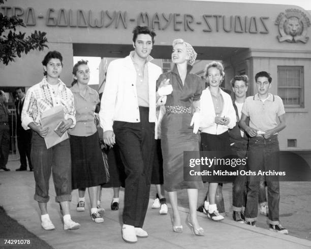 Rock and roll singer Elvis Presley with actress Barbara Lang and fans visits the MGM lot before starting work on the movie 'Jailhouse Rock' in...