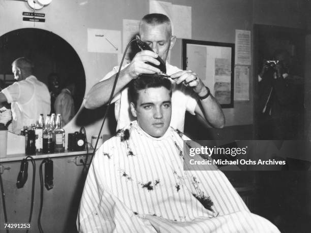 Rock and roll musician Elvis Presley gets his hair shorn off in preparation for his tour of duty in in the United States Army in 1959 in Germany....